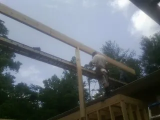 Carpenter setting a ridge beam over a new addition frame — Ice Dam Removal by Roofing Brothers in Coalville