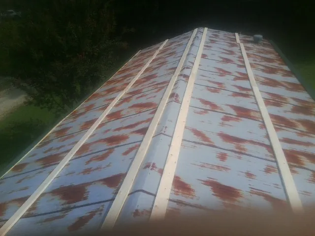 Rusted metal roof panels with new wood purlins before replacement — Storm Damage Roof Repair in Coalville by Roofing Brothers
