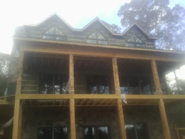 Dormers and porch framing on a large log home under construction — Roof Coating work by our crew in Coalville