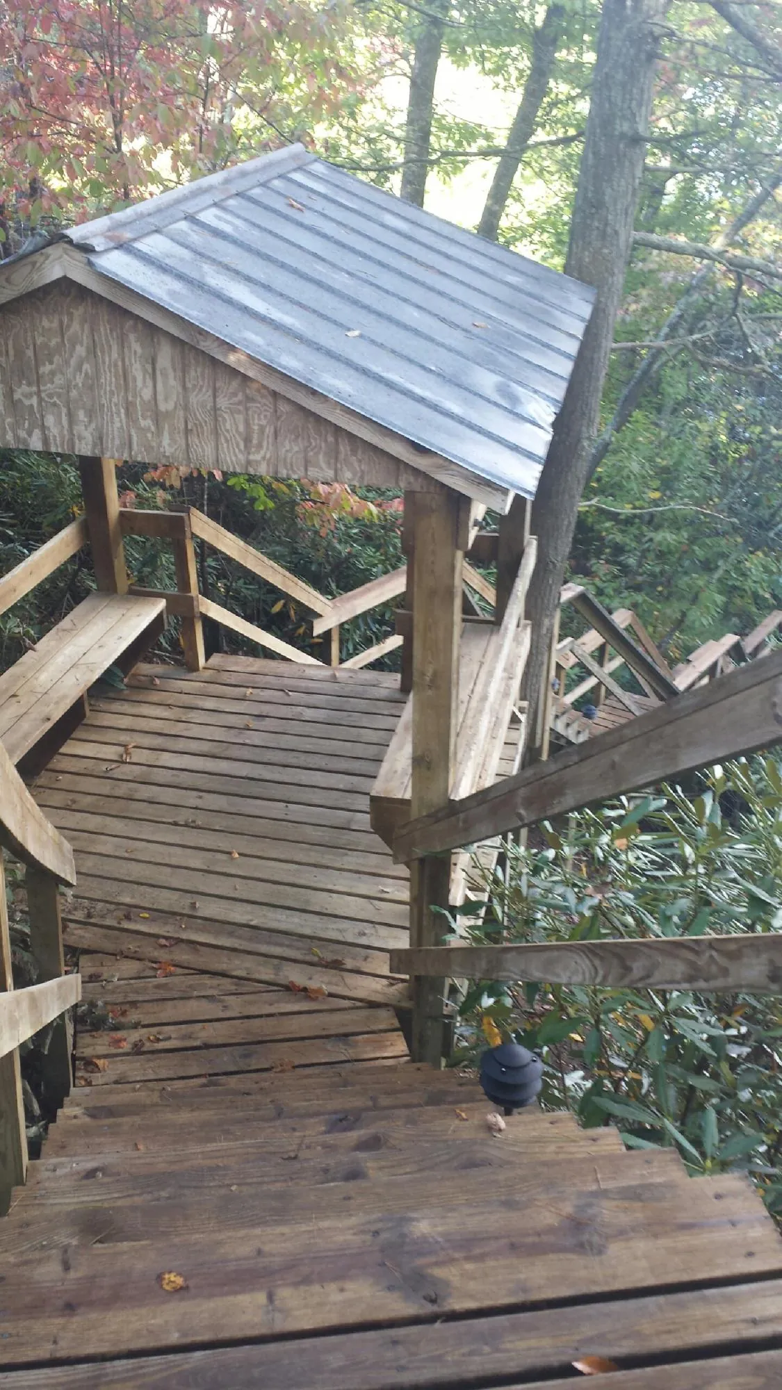 Metal roofed shelter over wooden steps on a wooded walkway — Skylight Repair & Installation work by our crew in Coalville