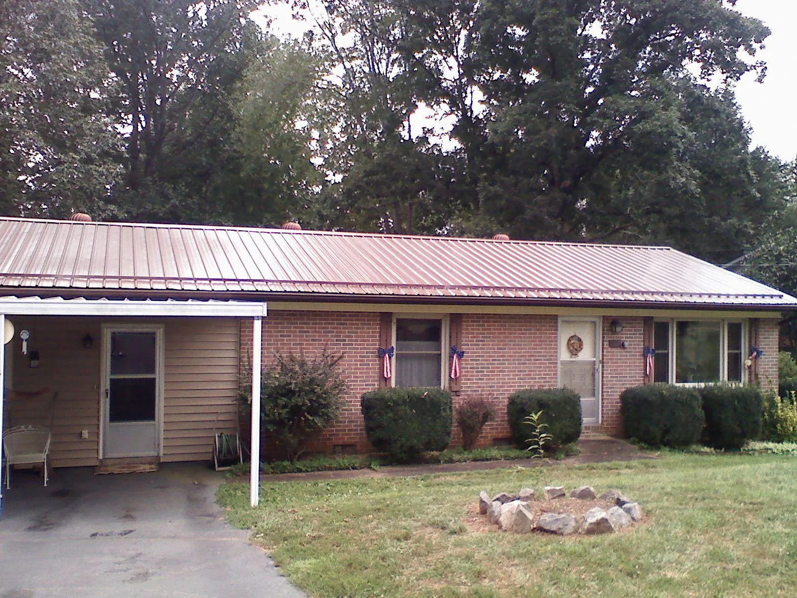 Bronze metal roof and carport on a brick ranch home — Roof Repair work by our crew in Coalville